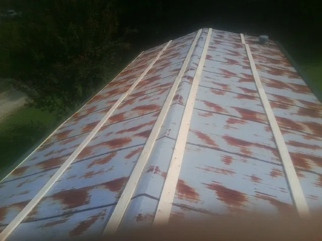 Rusted metal roof panels with new wood purlins before replacement — Storm Damage Roof Repair in Woodbine by Roofing Brothers