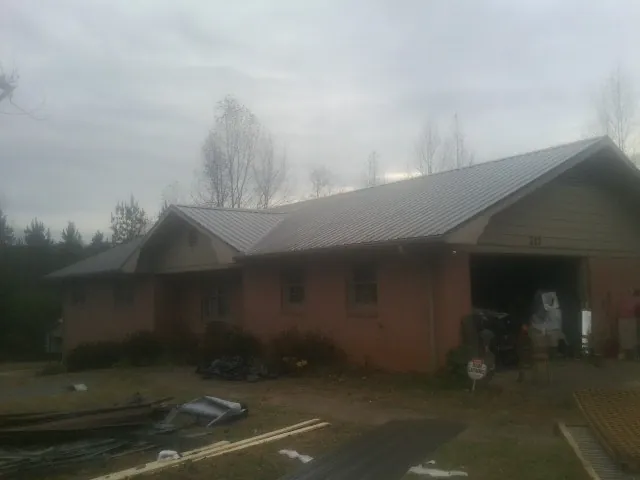 Gray metal roof on a stucco house with an attached garage in Woodbine